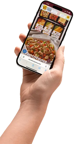 Hand holding smartphone displaying Demeter's Pantry website with Grab and Go and Foodservice Mediterranean & Hispanic prepared foods pages at demeterspantry.com