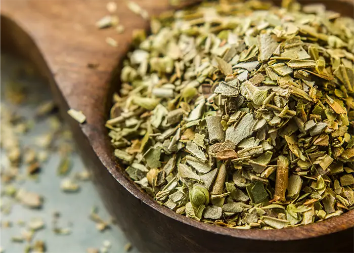 Mediterranean dried herbs and spice blend in a wooden spoon, used for natural and flavorful cooking