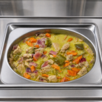 Demeter's Pantry Greek-style chicken with lemon garlic sauce in a foodservice hot bar pan, Mediterranean heat-and-serve entree for cafeterias and deli cases