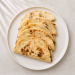 Fanned black bean and corn quesadillas on a white plate, made with Cotija and Monterey Jack cheese by Demeter's Pantry