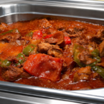Demeter's Pantry Chicken Stifado with red wine sauce, red and green peppers, and onions in a hot bar tray