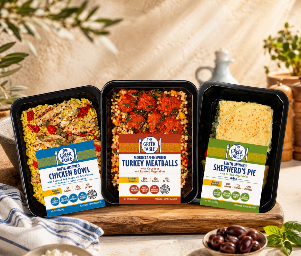 New packaging for The Greek Table lineup from Demeter's Pantry, featuring the Greek-Inspired Chicken Bowl, Moroccan-Inspired Turkey Meatballs, and Lentil Spinach Shepherd's Pie.