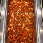 Demeter's Pantry Greek white bean stew with fire roasted tomatoes, carrots, and celery in a hot bar tray