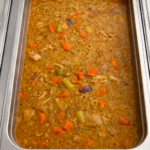 Demeter's Pantry Pollo Guisado Puerto Rican chicken stew with carrots, potatoes, and olives in a hot bar tray
